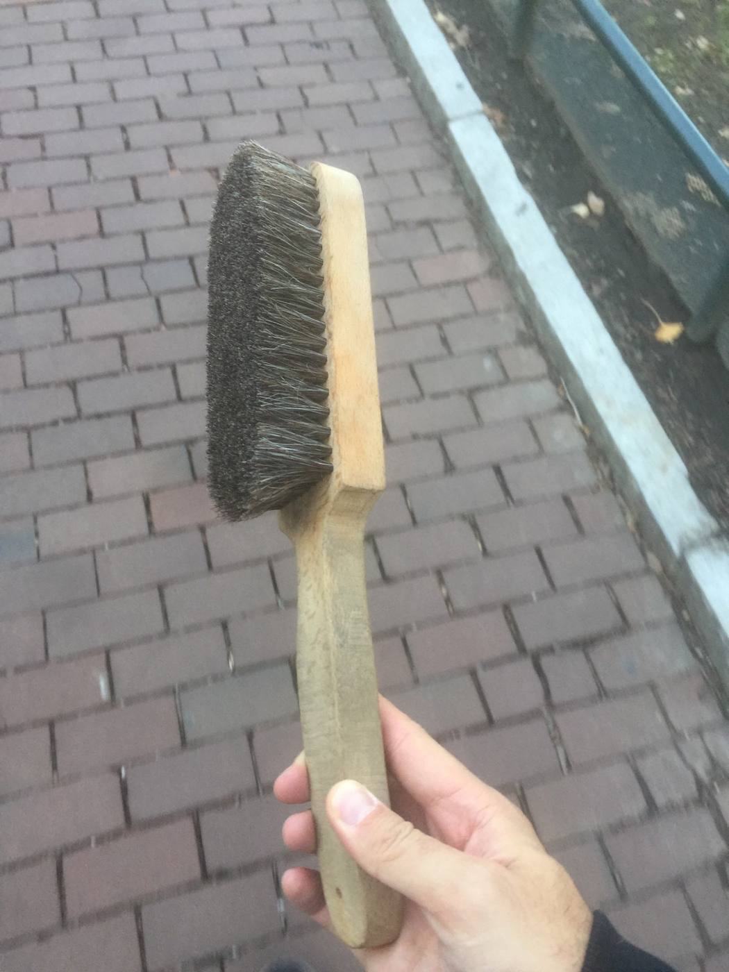 Actual: a squeeze brush answering the specification — close-set supple bristles in one even face, handle raised above the back