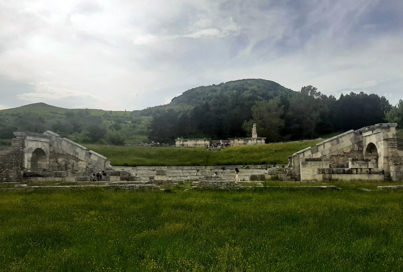 The surviving theatre at Pietrabbondante, with Temple B and Monte Saraceno behind it.